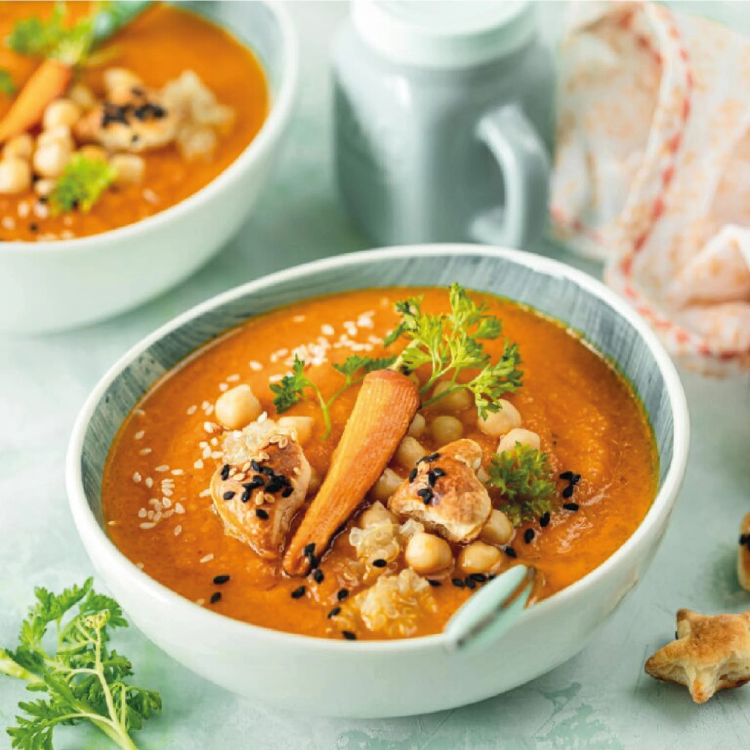 Karotten-Kichererbsen-Suppe mit Hähnchen Cremige Karotten-Kichererbsen-Suppe mit Hähnchen und Babykarotten, serviert mit frischen Kräutern