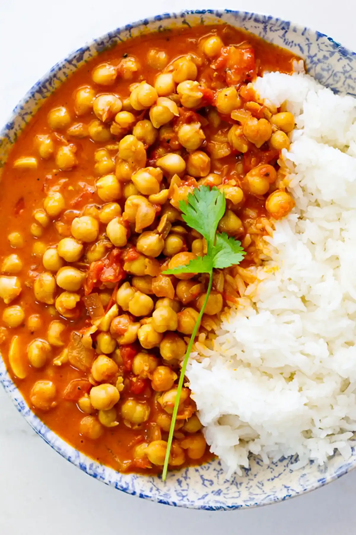 "Kichererbsen Curry mit weißem Reis in einer dekorativen Schüssel, von oben fotografiert